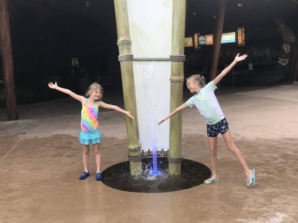 2 girls posing around a fountain